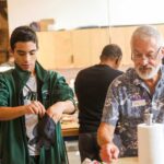 Mentor teaching cooking skills to boy in Son of a Saint life skills program New Orleans